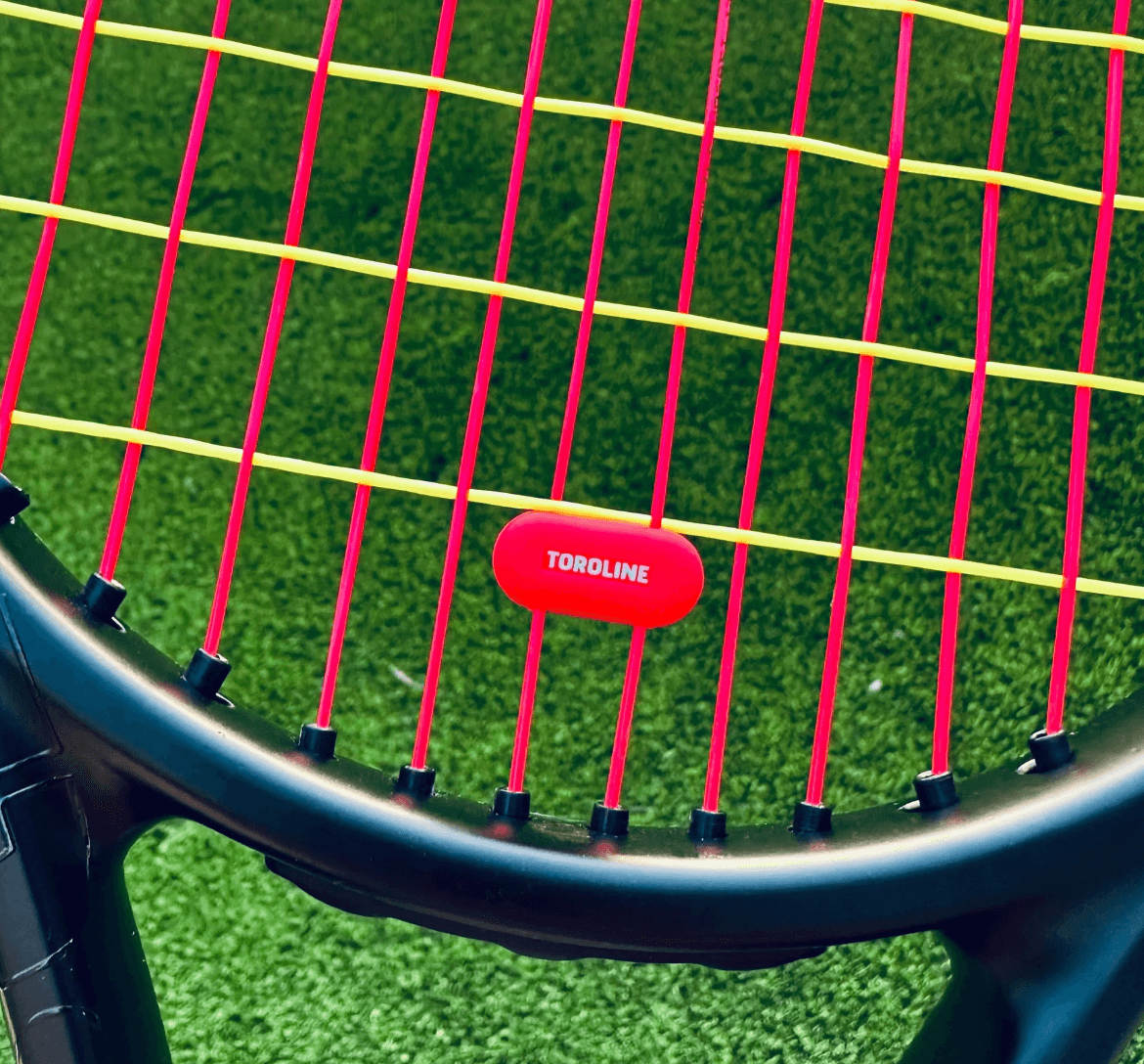 yellow and pink tennis strings by toroline on a racquet with a pink toroline dempener