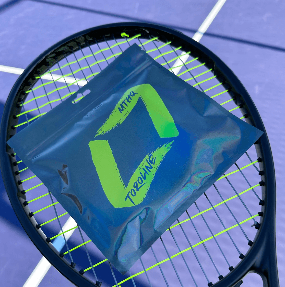 a pack of toroline tennis strings on a tennis racquet with yellow and black strings