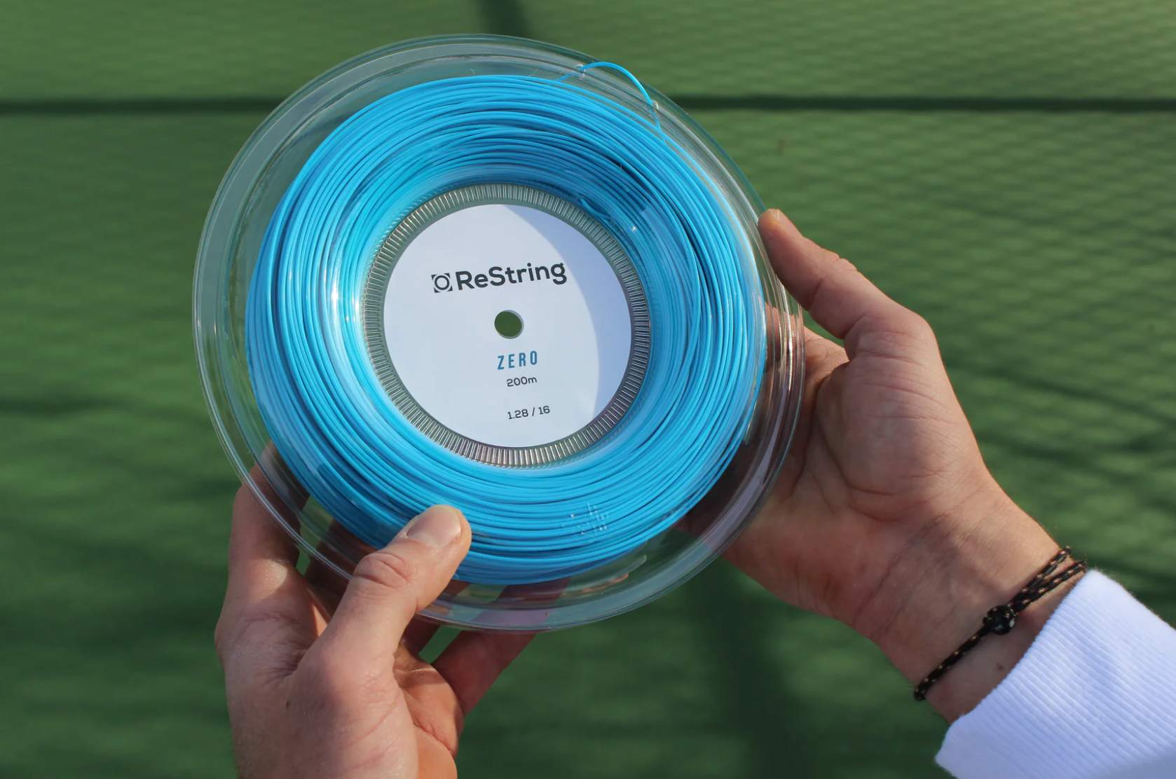 guy holding restring zero reel in 128 gauge in blue colour